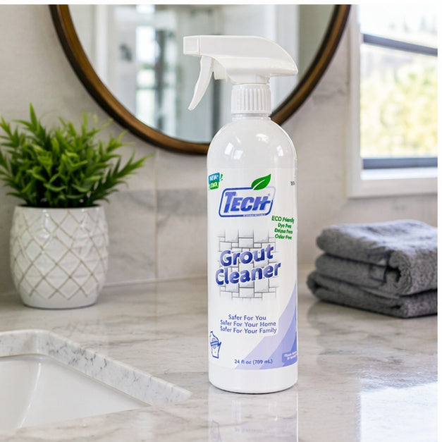 Bottle of Tech Grout Cleaner on a bathroom counter with a mirror and plant in the background